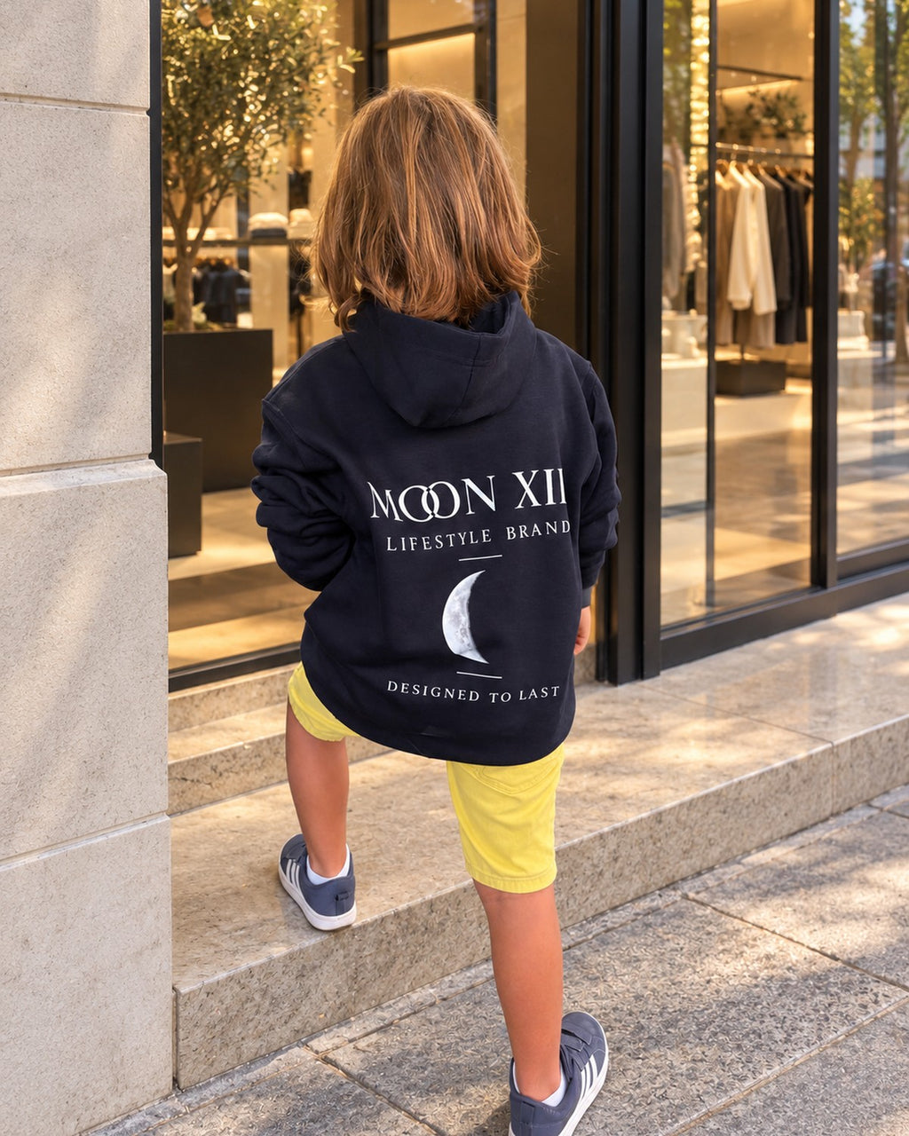 Heritage Navy Junior Hoodie — boy from behind, Moon XIII logo with the crescent moon