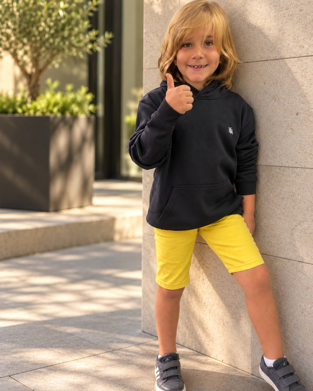 Heritage Navy Junior Hoodie — boy leaning against a wall, front view