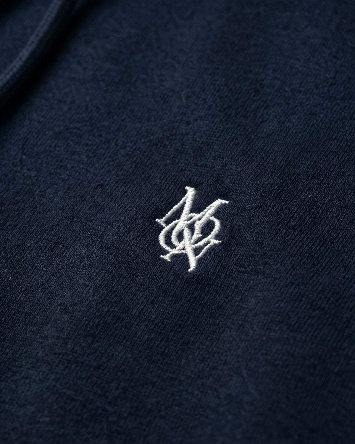 Sudadera con capucha Heritage Navy — detalle del monograma Moon XIII bordado en el pecho