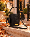 Bolso Capri Noir — bodegón en unos escalones de piedra con hojas de otoño, con la bandolera